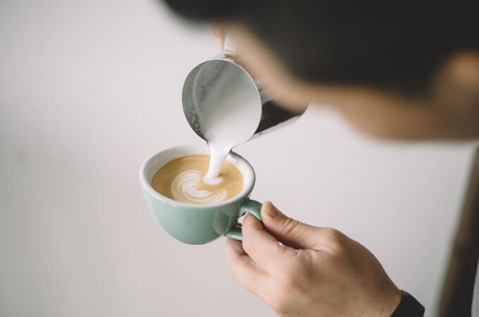 milk being poured into a latte