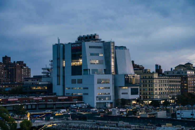 A New York city skyline with the Whitney museum front and center at dusk
