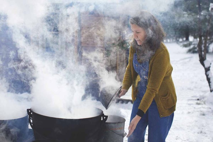 woman cooking in big pot with steam