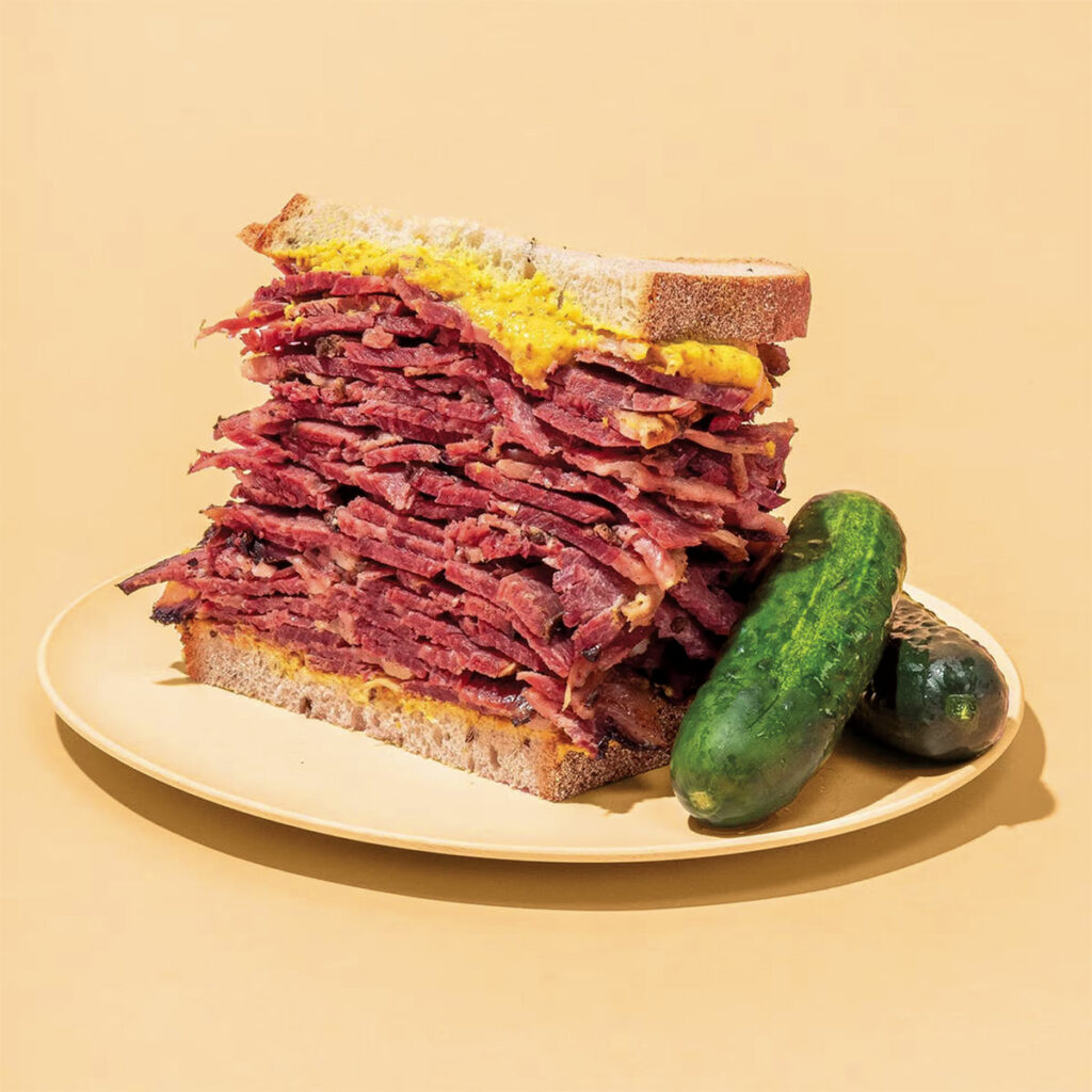 thick pastrami sandwiches with a slathering of mustard and two pickles