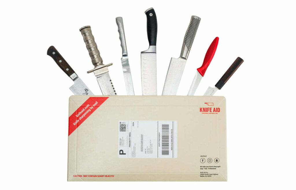 a cardboard mailing envelope with seven kitchen knives sticking out of it