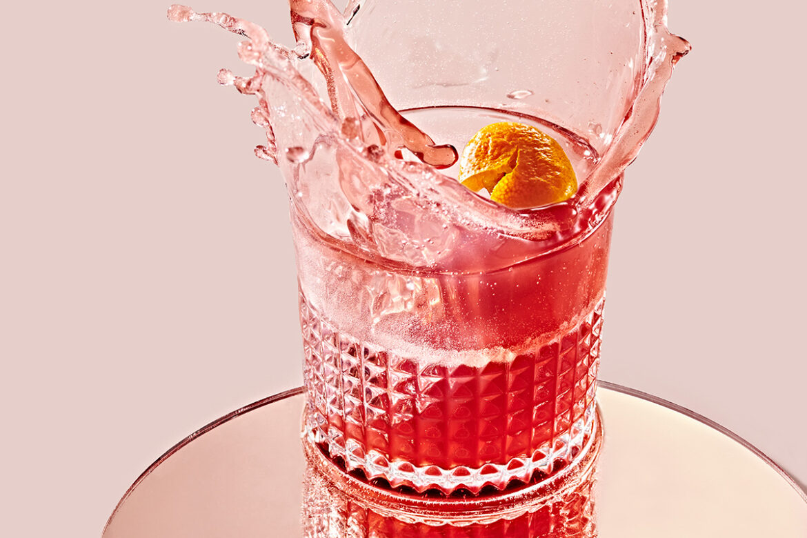 pink-red sorel cocktail splashing out of glass
