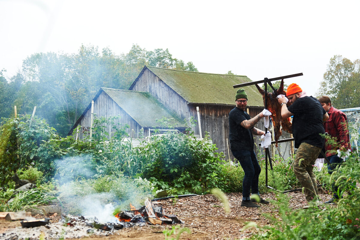 chefs putting pork over a live fire