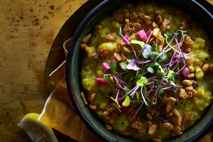 kitchari in a dark colored bowl with a lemon wedge on the side