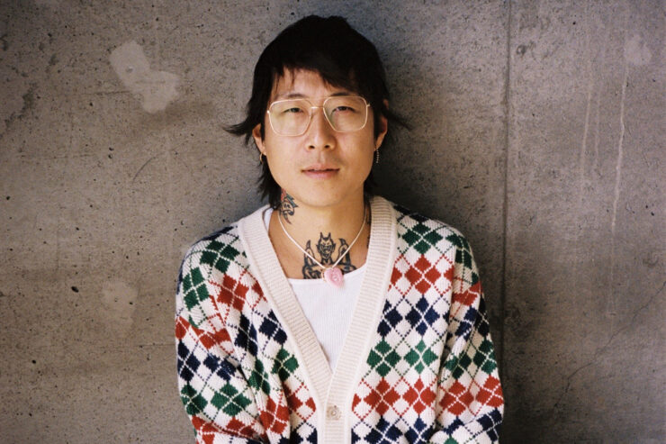 portrait of danny bowien standing against a concrete wall
