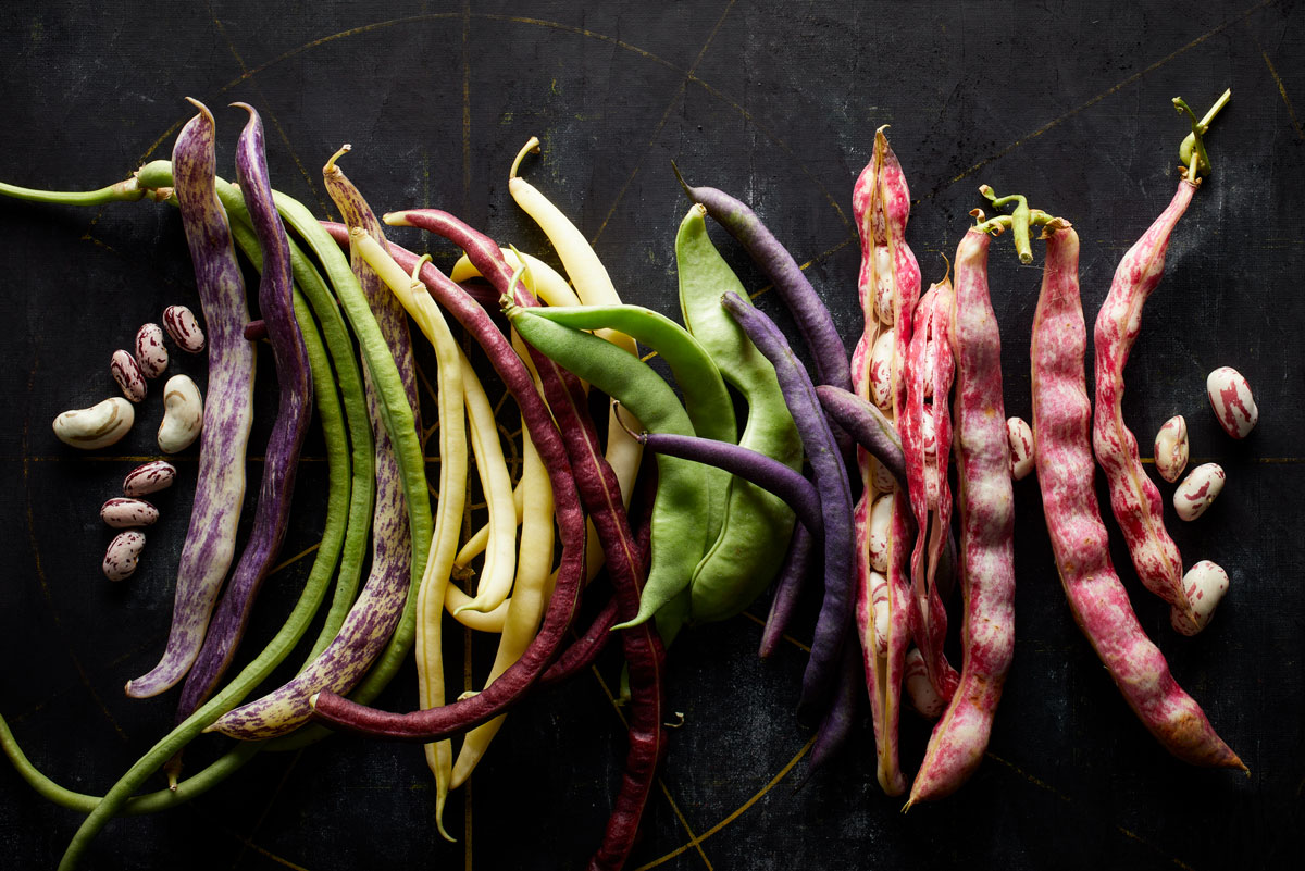 colorful snap and shell beans on a black background