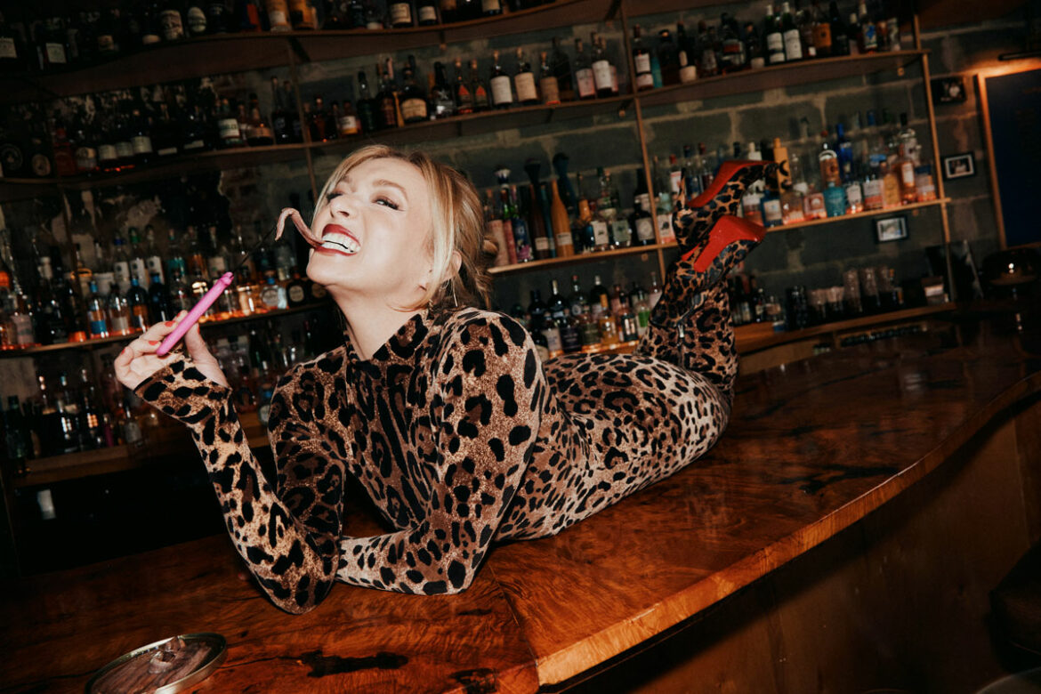 influencer emily fedner lays across a bar eating an anchovy