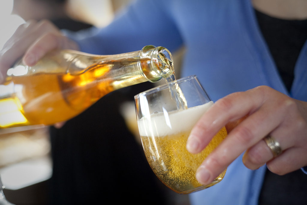 pouring hard cider into a glass
