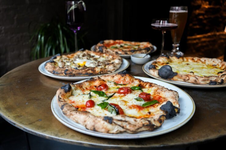 freshly made pizzas on a table with drink pairings